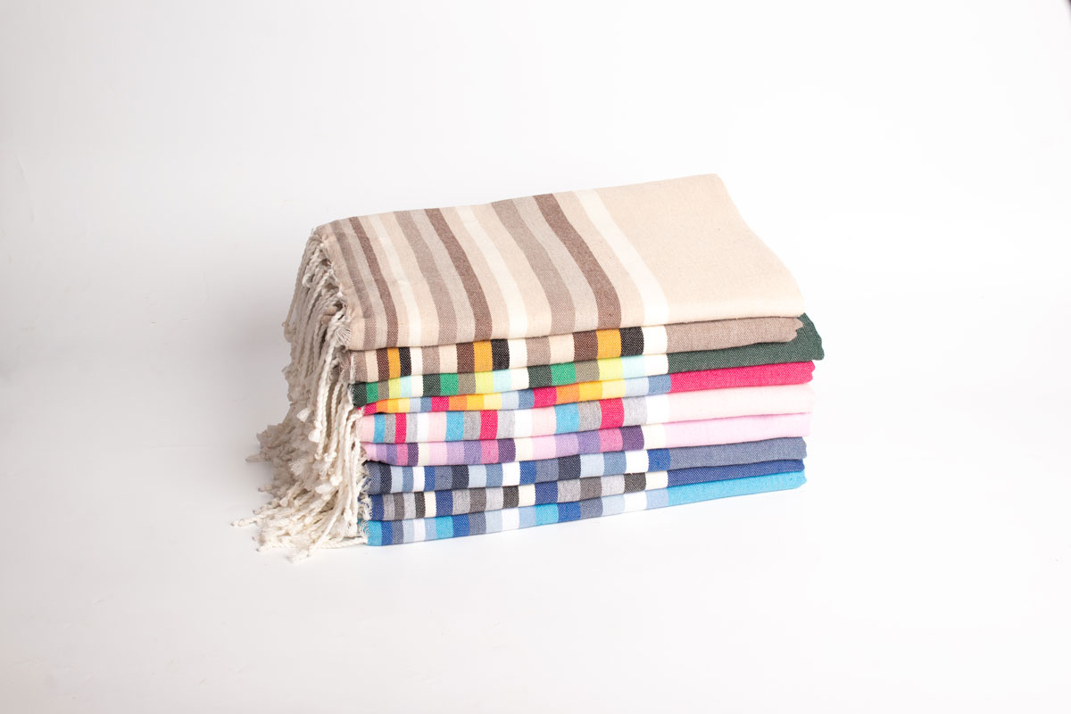 Artisan fabriquant une fouta en coton biologique, illustrant les avantages écologiques des serviettes fouta