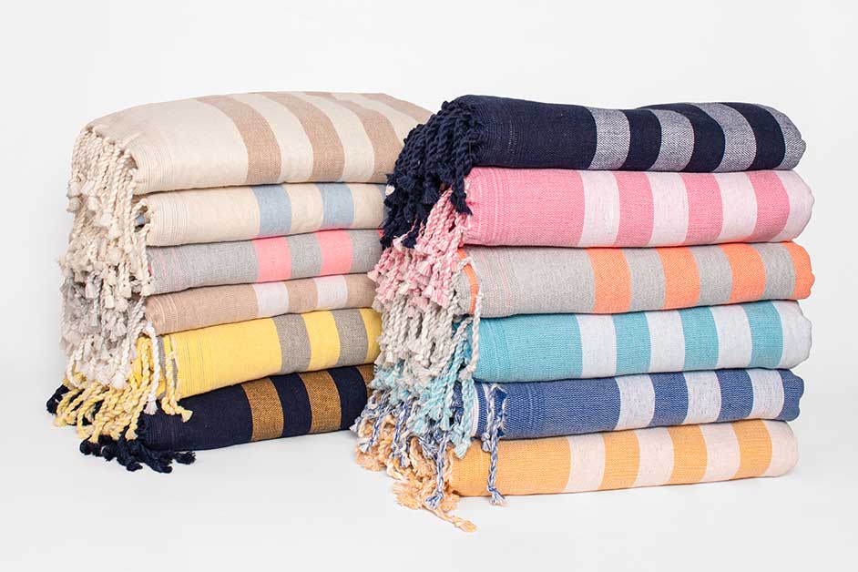 Piles de couvertures rayées colorées sur fond blanc.