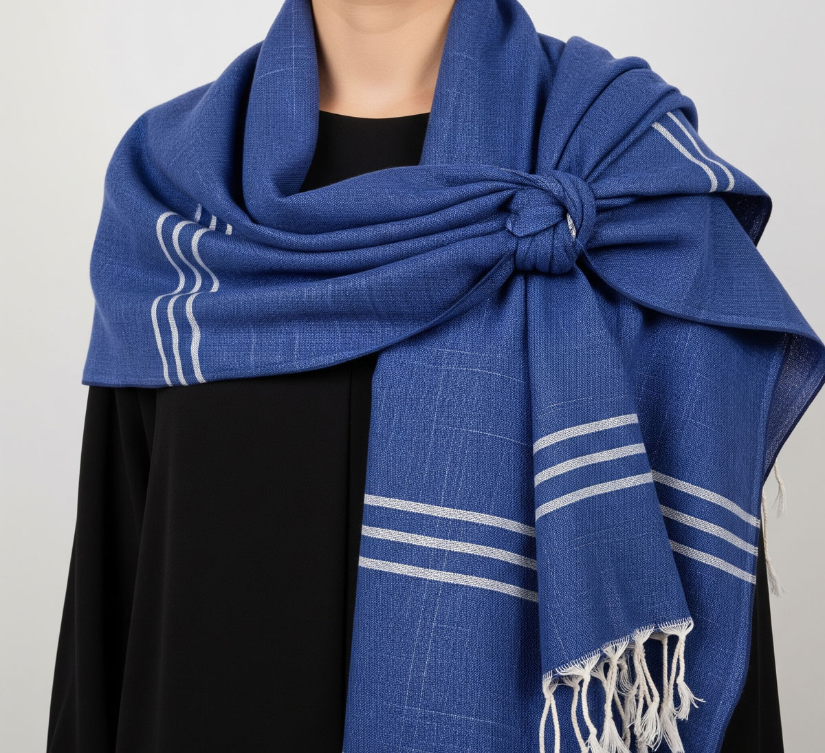 Une fouta bleue stylisée en un élégant châle, montrant comment utiliser une fouta comme écharpe de manière sophistiquée.