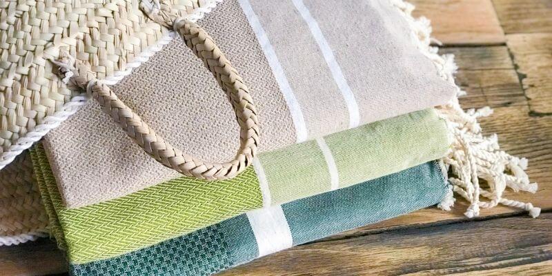 Sac en toile et serviettes colorées empilées.